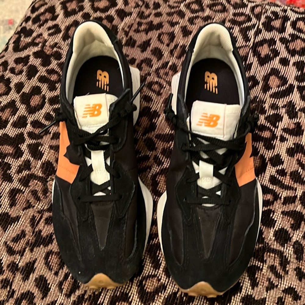 New balance tennis shoes used slight wear on toes. Black and tan stripes.size7